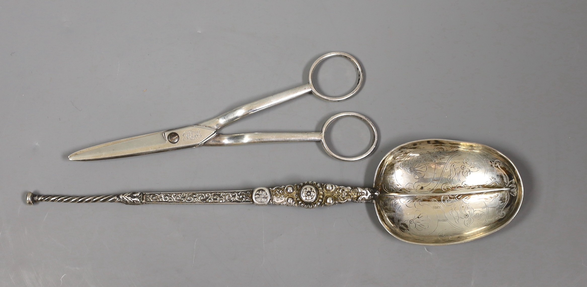 A pair of George III silver grape scissors, by Eley & Fearn, London, 1818 and a George V silver replica of the anointing spoon, Goldsmiths & Silversmiths Co Ltd, London 1910, 166 grams.